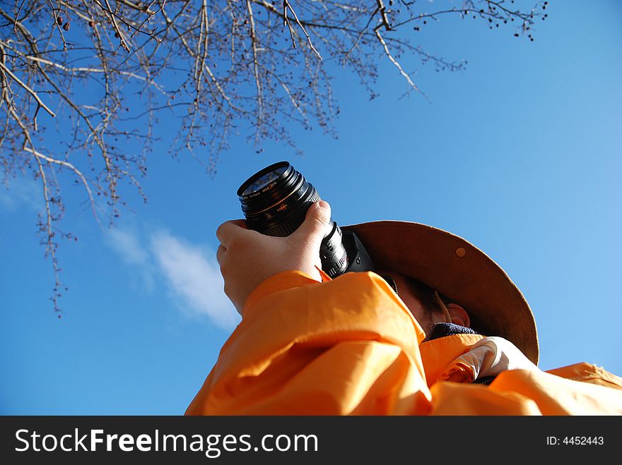 Young man taking picture outdoor, blue sky in background. Young man taking picture outdoor, blue sky in background.