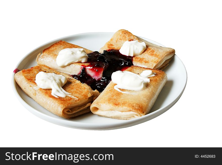 Pancakes with sour cream and jam at the plate on a white background