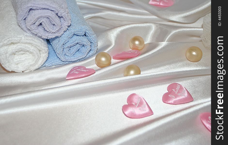 The still life with soap, towels and hearts over silk. The still life with soap, towels and hearts over silk