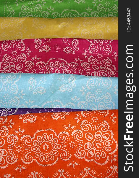 A collection of colorful, patterned  cloth bandanas.