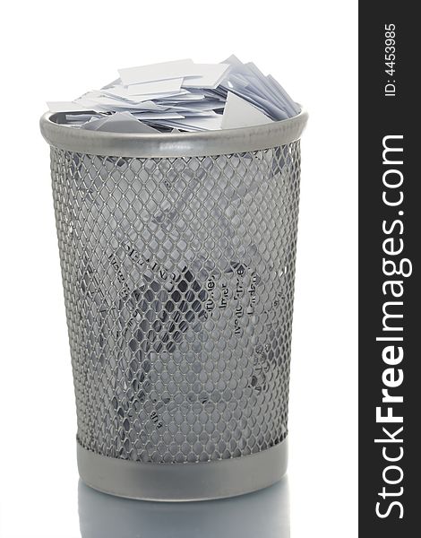 Mesh trash bin full of small paper pieces. Mesh trash bin full of small paper pieces