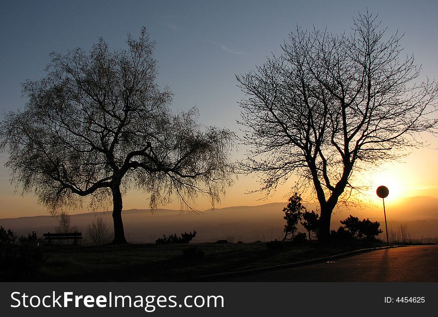 Sunset behind the silhouette the traffic sing. Sunset behind the silhouette the traffic sing