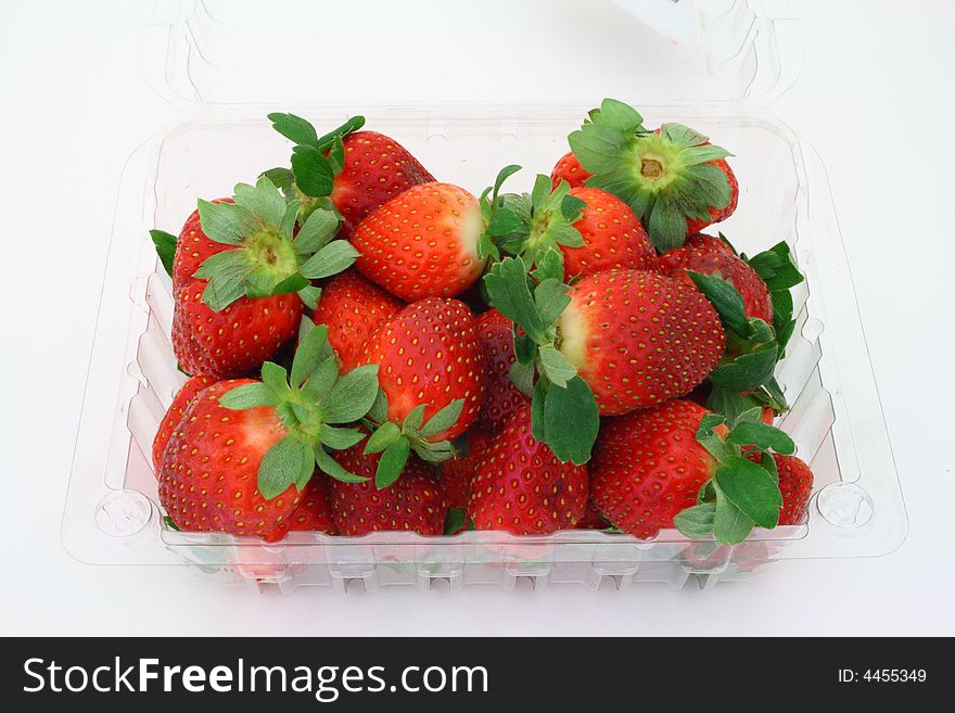 Basket with fresh strawberries on a white surface
