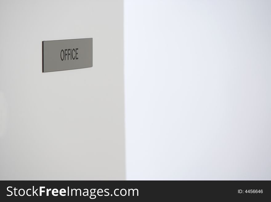 A office sign on a door in a hallway