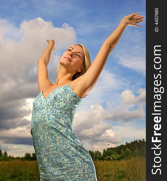 Pretty young woman over blue cloudy sky