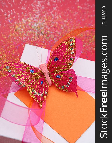 Pink butterfly on a white gift box as a decoration. Pink butterfly on a white gift box as a decoration