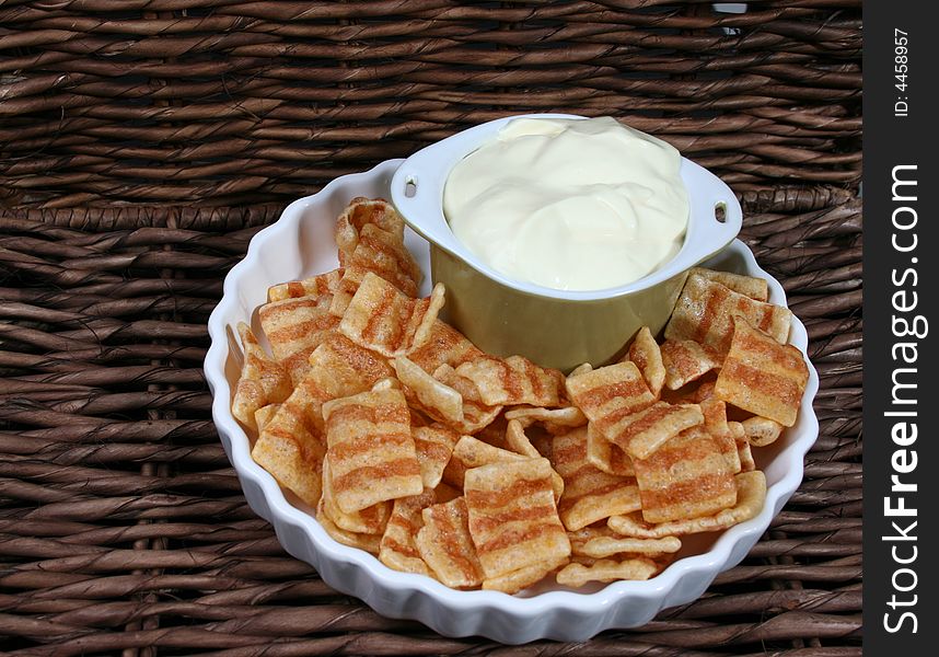 Chips in a white bowl with dip in a green bowl. Chips in a white bowl with dip in a green bowl