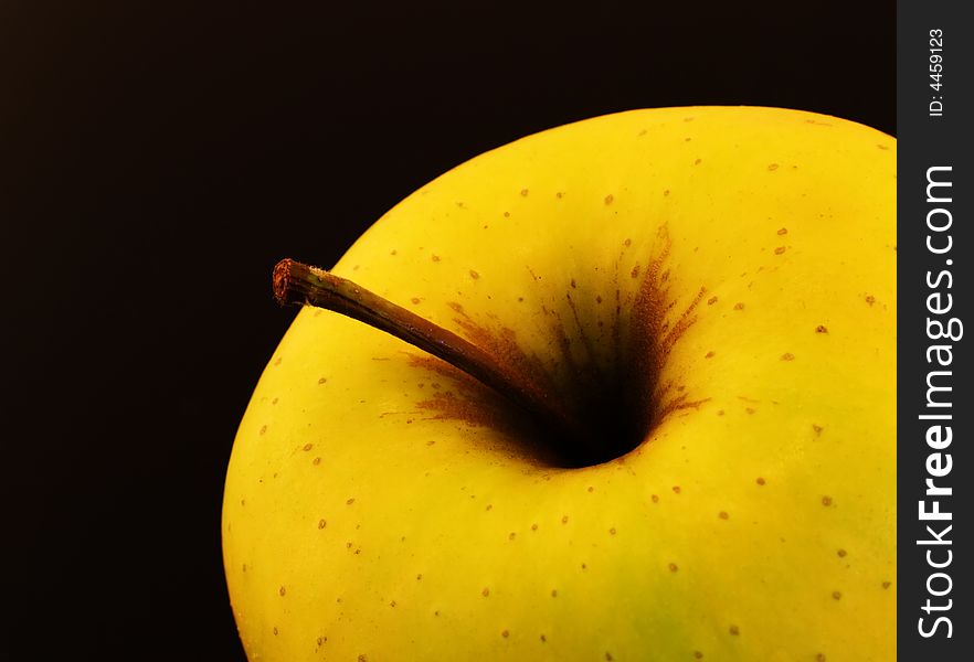 Yellow apple on a black background for a strong chromatic contrast. Yellow apple on a black background for a strong chromatic contrast