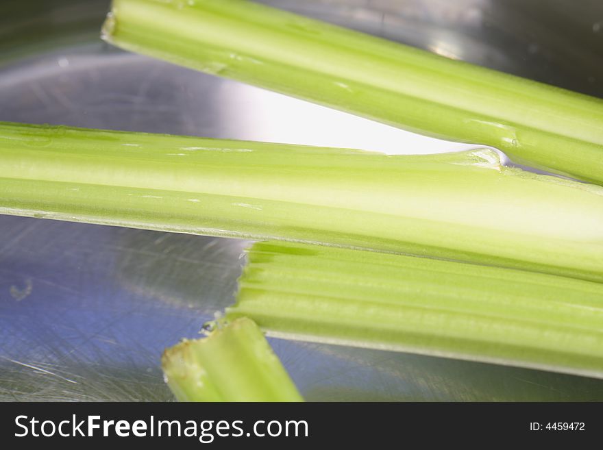 Green Celery floating around in a pot with water. Green Celery floating around in a pot with water.