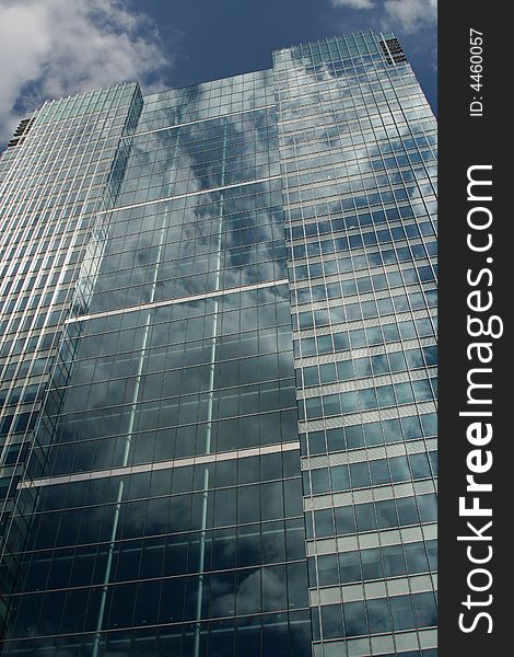 Clouds reflecting on side of glass office building