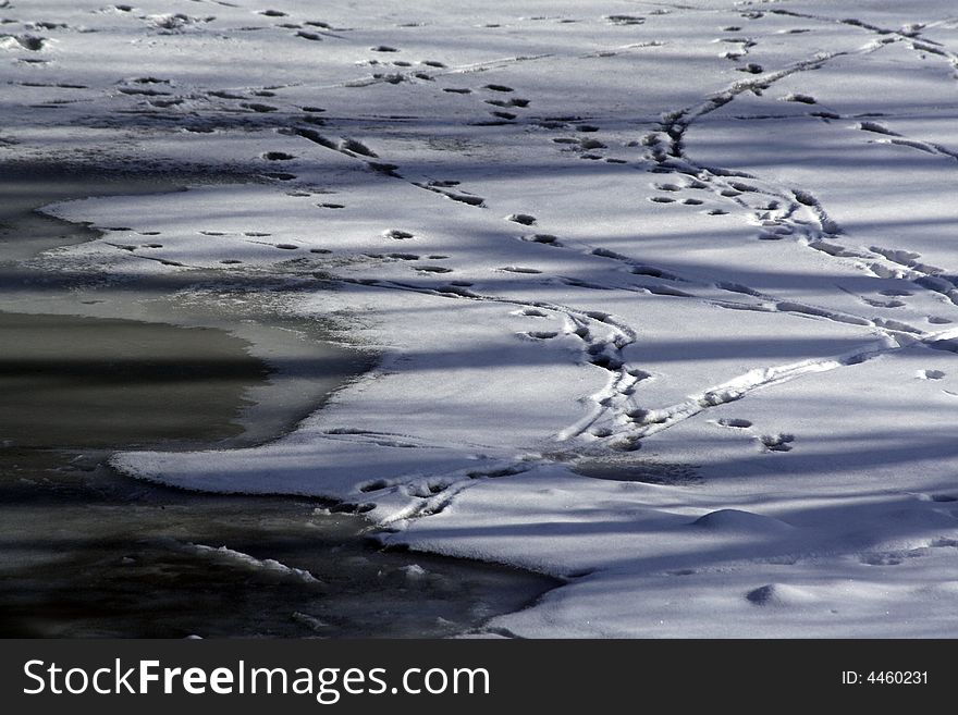 Footsteps in the snow over frozen river