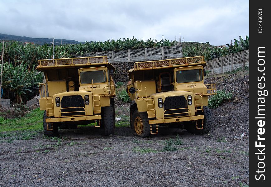 A view at two older caterpillar trucks. A view at two older caterpillar trucks.