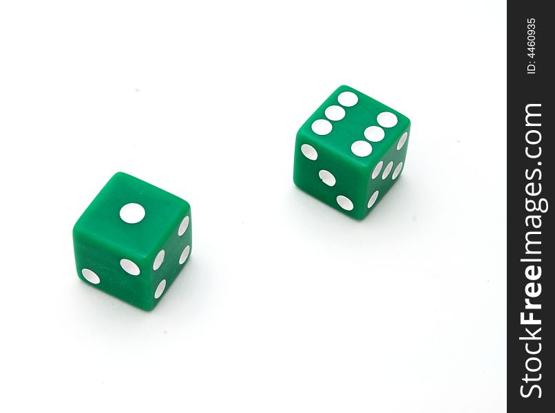 Two green dice on a white surface