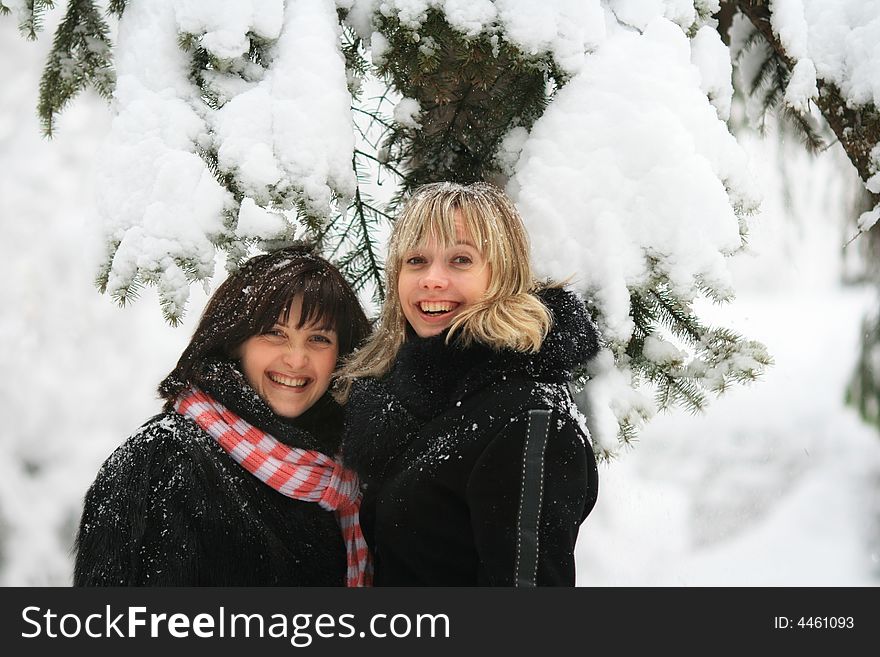 Portrait of two smiling girls on a background of a snow