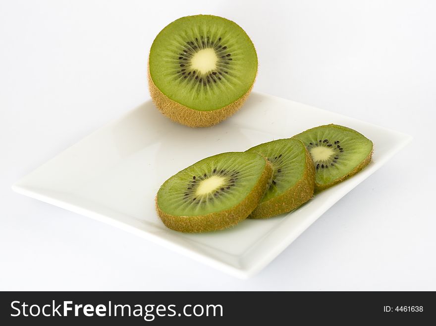 A sliced kiwi on a dish. A sliced kiwi on a dish