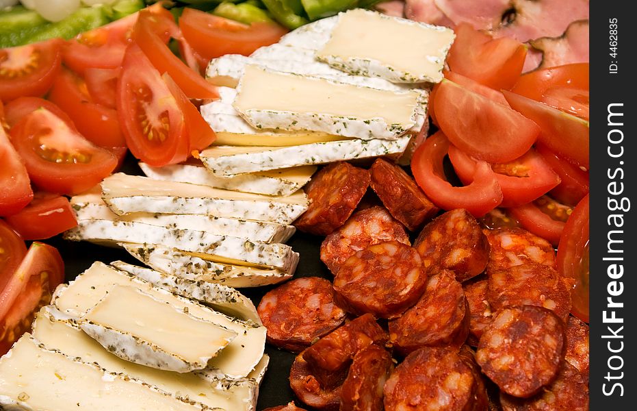 Closeup of cheese, cold meat and fresh vegetables. Closeup of cheese, cold meat and fresh vegetables