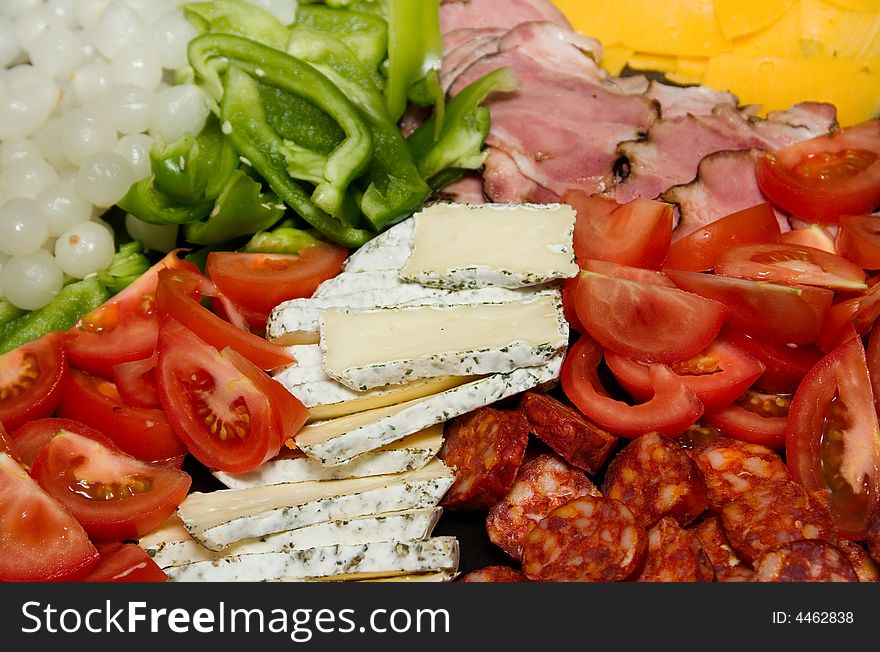 Closeup of cheese, cold meat and fresh vegetables. Closeup of cheese, cold meat and fresh vegetables