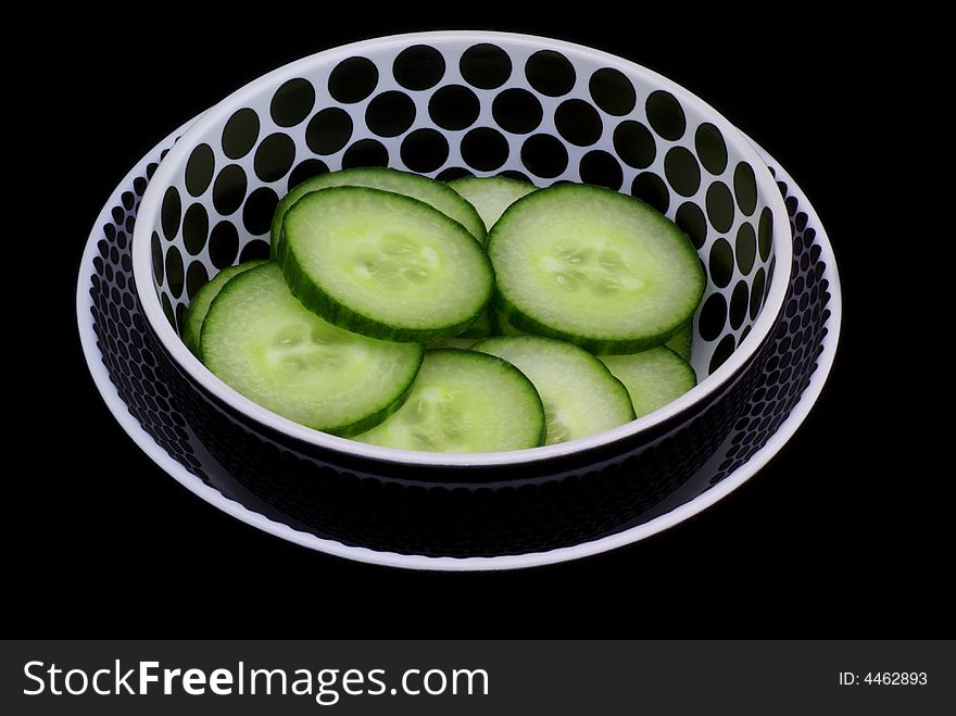Isolated black/white bowl with cucumber slices. Isolated black/white bowl with cucumber slices.