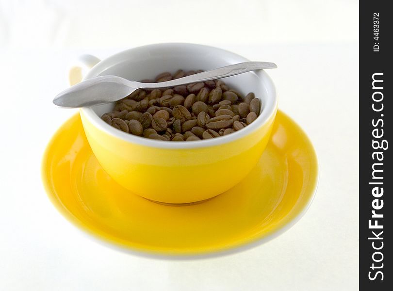 Yellow cup of coffee seeds
