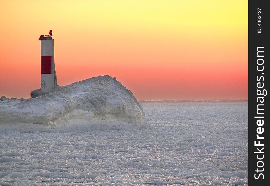 Channel marker covered in icy at sunset time. Channel marker covered in icy at sunset time.