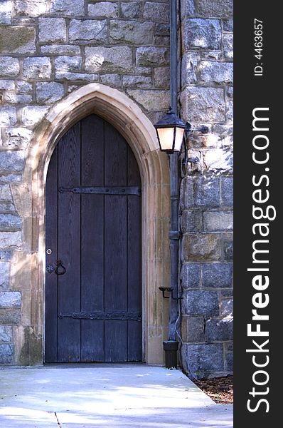 Vintage arched wood door in rock wall of an old church. Vintage arched wood door in rock wall of an old church.