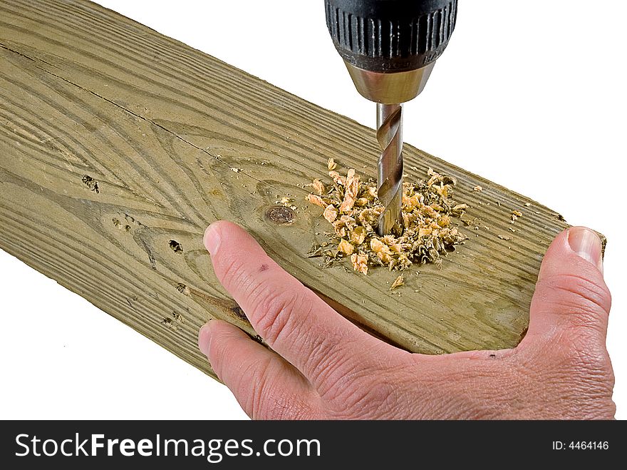 Hand holding board that is being drilled into. Hand holding board that is being drilled into