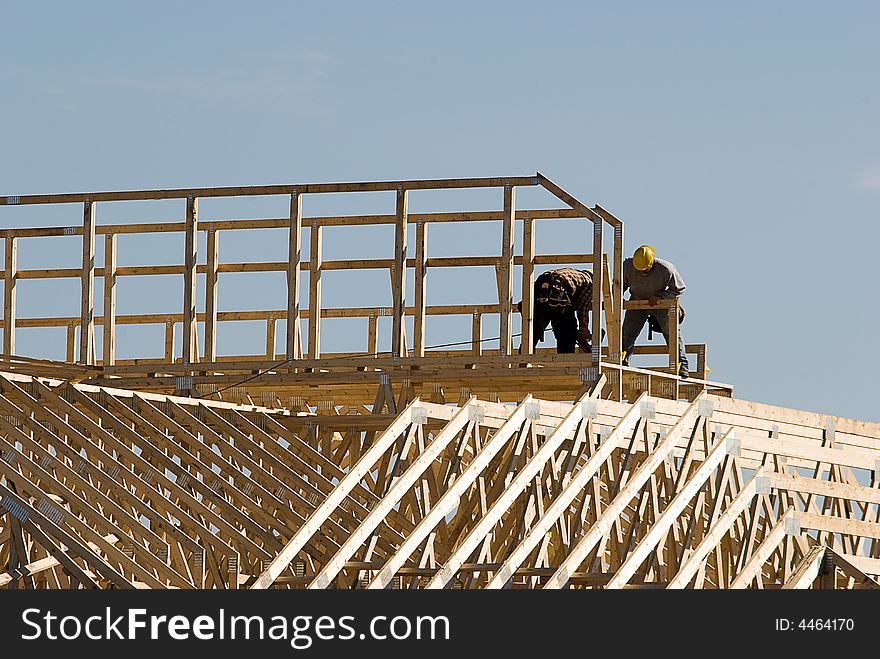 Two men working on top of new construction. Two men working on top of new construction