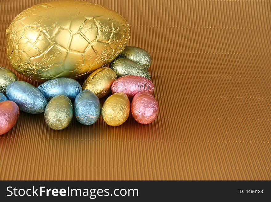 Various colors and shaped easter eggs on a gold background