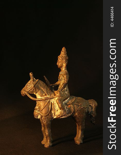 A small bronze figurine of an chinese warrior mounted on a horse. A small bronze figurine of an chinese warrior mounted on a horse