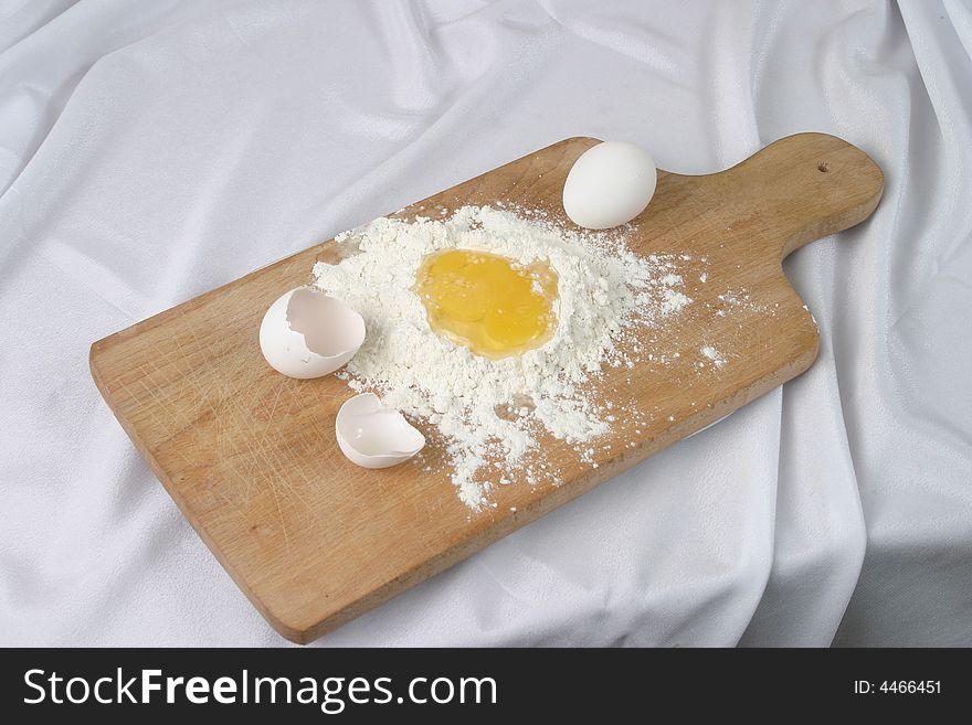 Eggs and a flour on a board