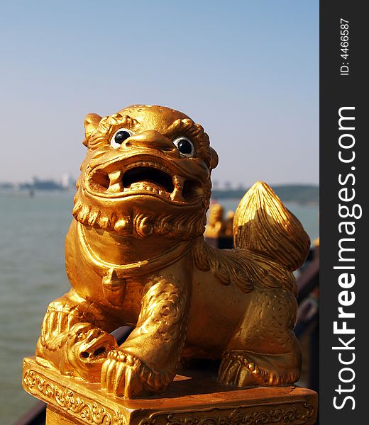 A carving golden lion is opening mouth on the beach. A carving golden lion is opening mouth on the beach.