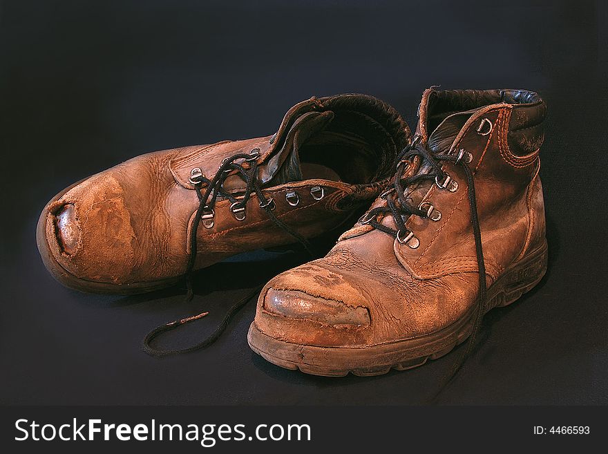 Worn out boots with  exposed steel caps. Worn out boots with  exposed steel caps