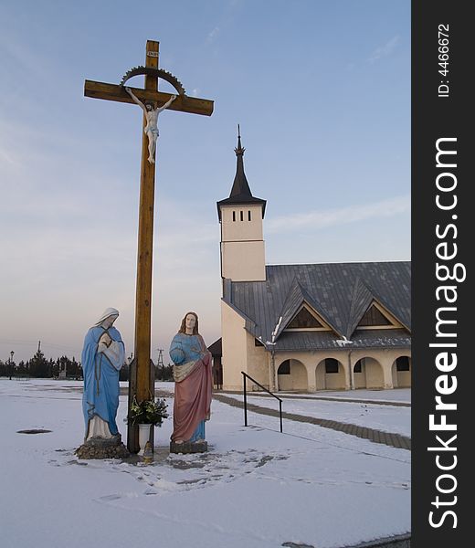 Jesus on the cross. In background small beauty church