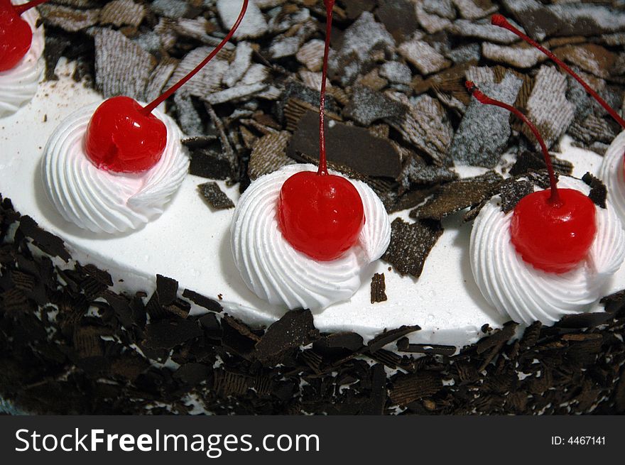 Black forest cake decorated with cherries.