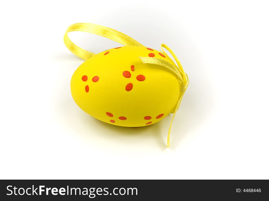 One yellow easter egg with gold ribbon isolated on white