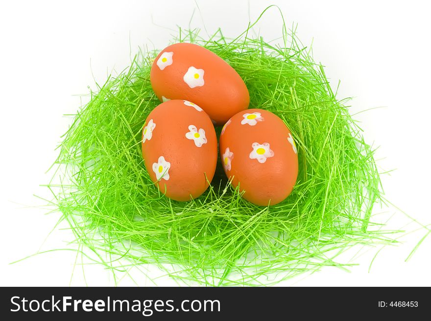 Three red easter eggs with green grass isolated on white