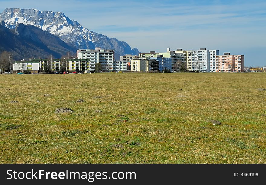 Apartment block on a green field and mountains. Apartment block on a green field and mountains