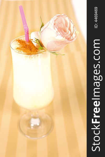 Creamy cocktail with cinnamon and a rose decoration