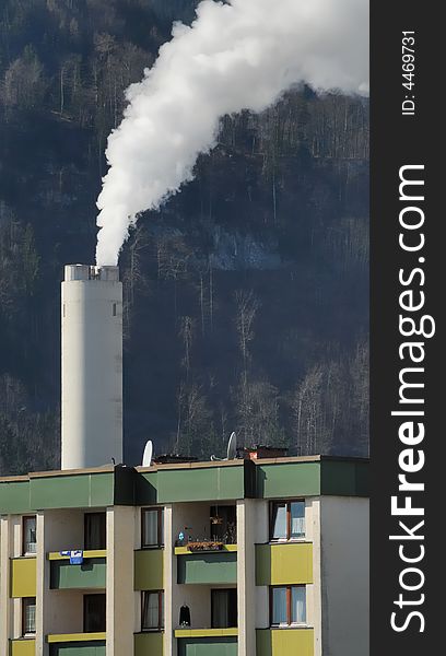 Steaming chimney and apartment building in the city. Steaming chimney and apartment building in the city