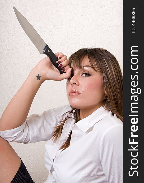 A female business person resting a knife on her forward as she looks at the camera. A female business person resting a knife on her forward as she looks at the camera.