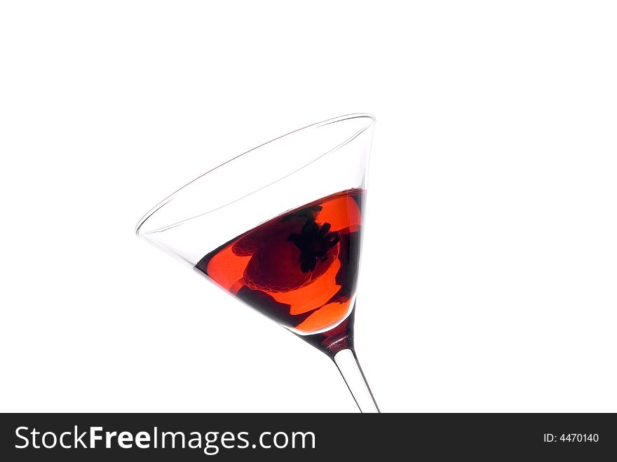 A tilted view of strawberry martini with a strawberry on white. A tilted view of strawberry martini with a strawberry on white