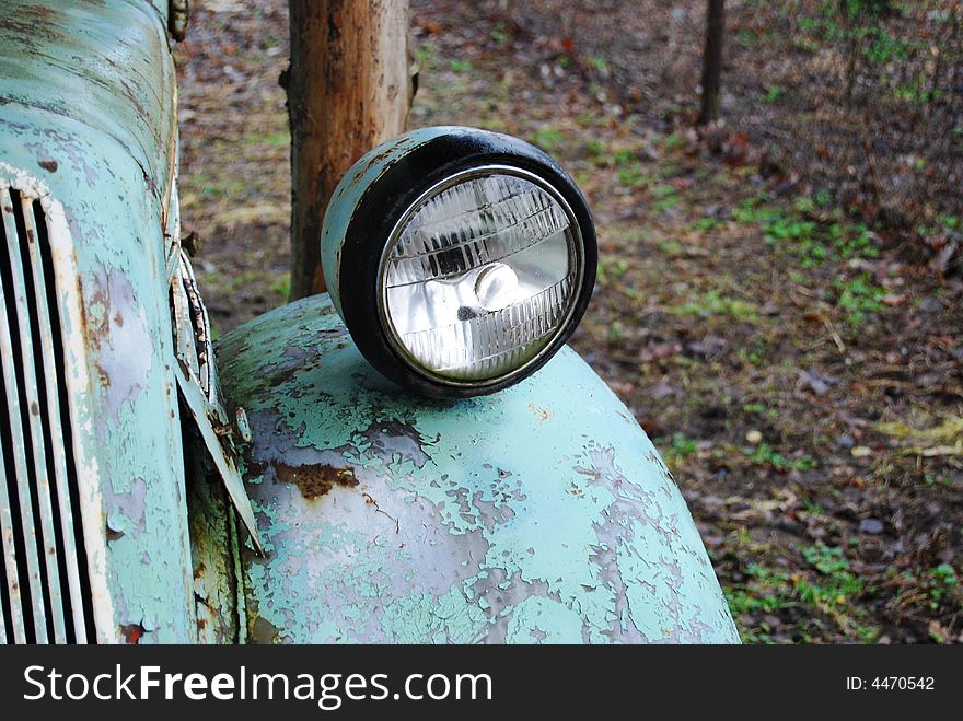 Crushed and rusted antique car frontlight view close-up. Crushed and rusted antique car frontlight view close-up