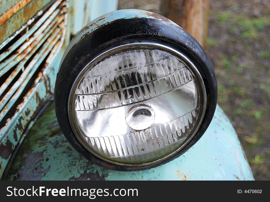 Crushed and rusted antique car frontlight view close-up. Crushed and rusted antique car frontlight view close-up