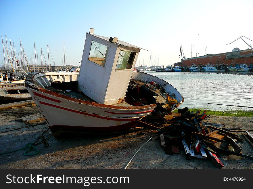 A ruined wooden boat in a boat-yard. A ruined wooden boat in a boat-yard