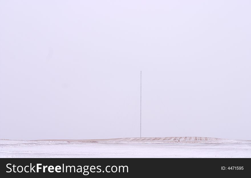 A TV Antenna set against a white sky with snow on the ground. A TV Antenna set against a white sky with snow on the ground