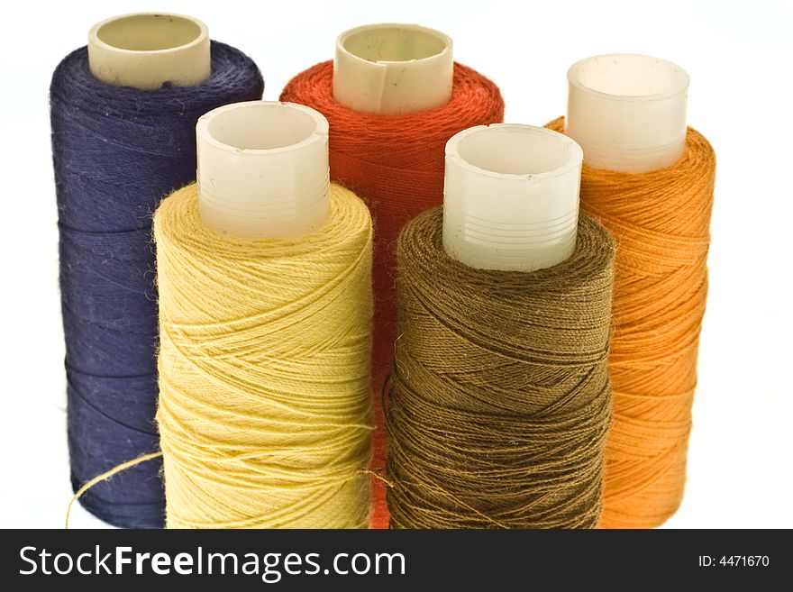 Five isolated spools with threads of different colors. Five isolated spools with threads of different colors