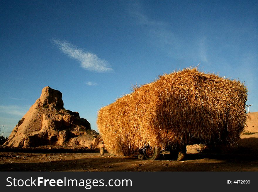 In gansu province of china, an old tractor in front of 1st centry military castle, fill up straw. In gansu province of china, an old tractor in front of 1st centry military castle, fill up straw.