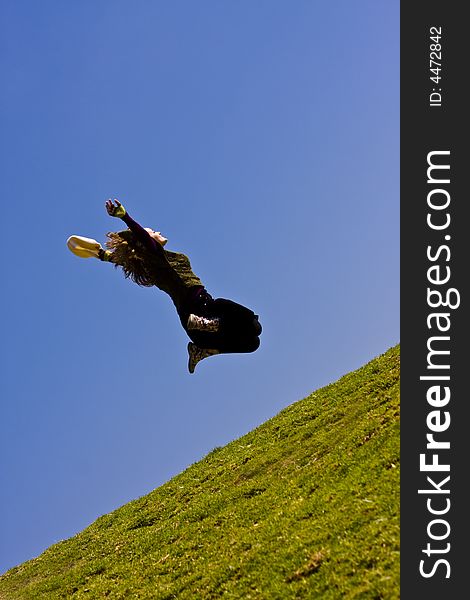 Happy young woman jumping over the grass