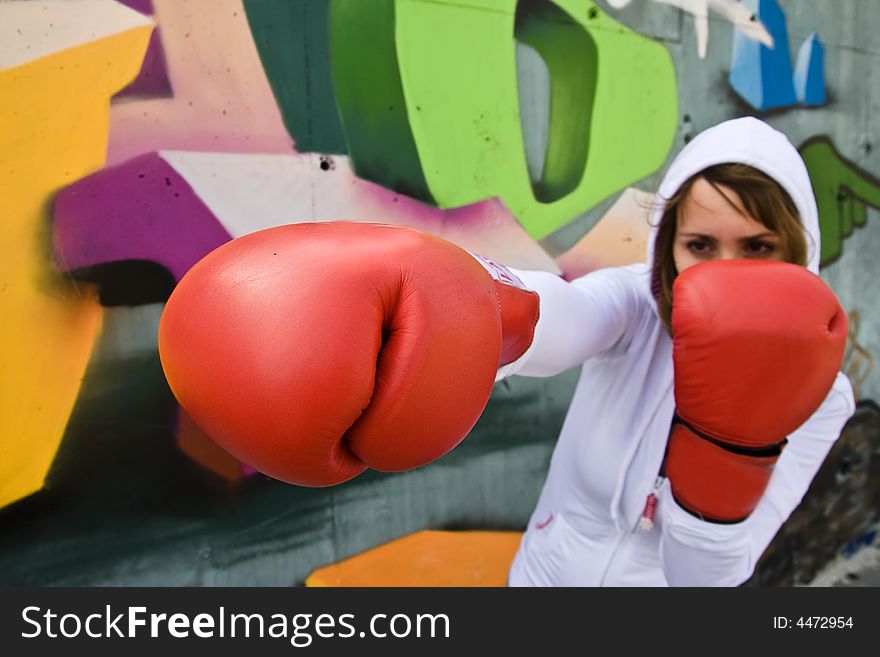 Boxing woman over graffiti background, focus on glove. Boxing woman over graffiti background, focus on glove.