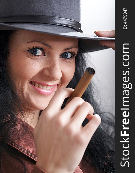 An image of a beautiful woman in felt hat with cigar. An image of a beautiful woman in felt hat with cigar